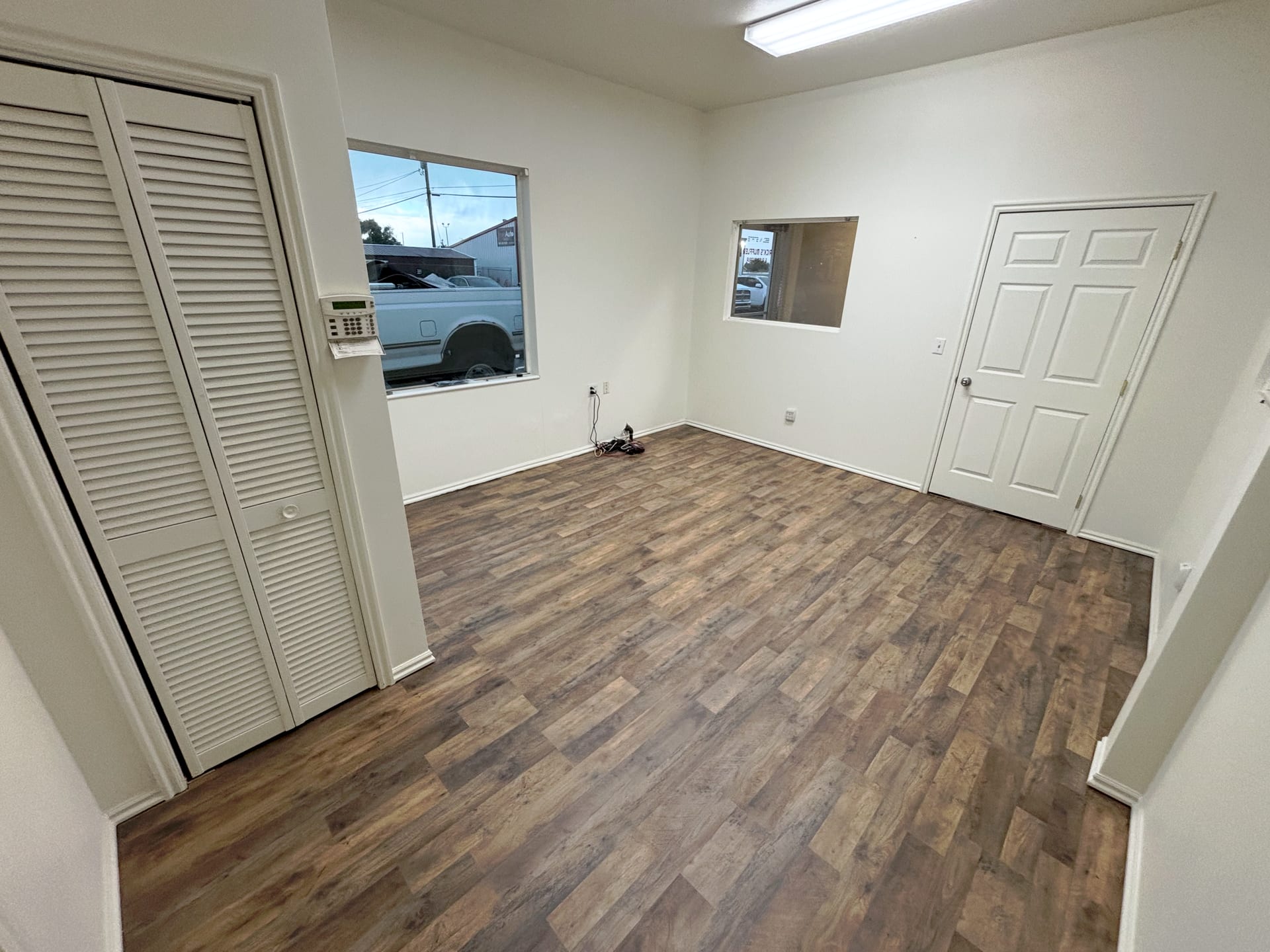 Same bedroom with new light wood-look plank flooring installed wall to wall